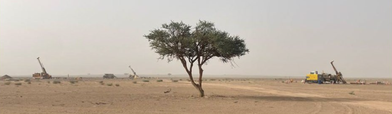 Drill rigs testing Sierra Nevada Gold's As Safra SE copper-gold targets on flat desert terrain in Saudi Arabia.
